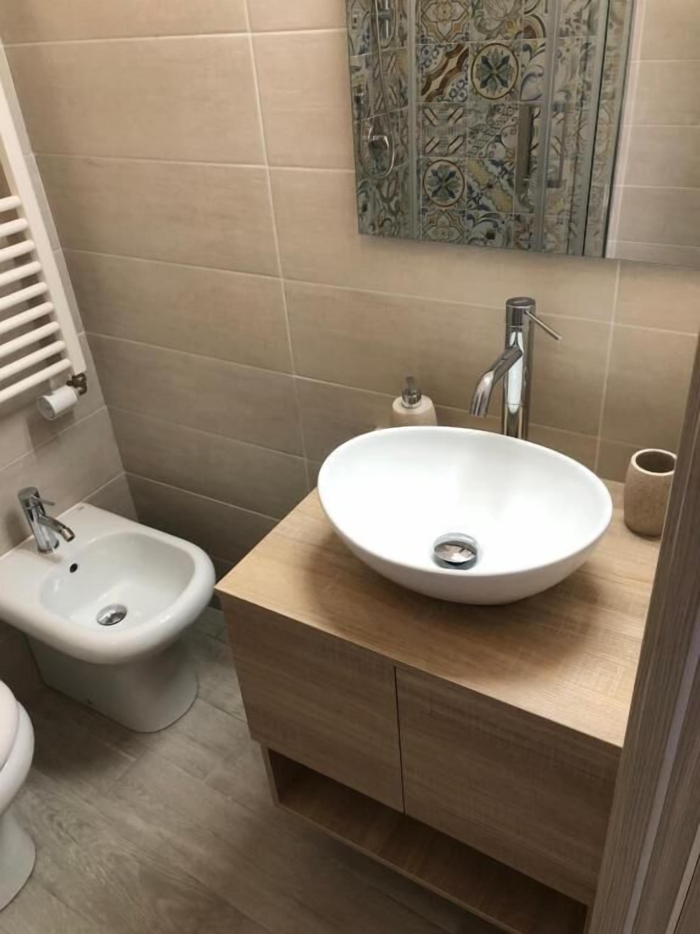 Ein Badezimmer mit einem weißen Waschbecken, einem Bidet und einer Toilette.