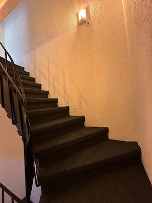 Eine Treppe mit Handlauf und einer Wandleuchte.