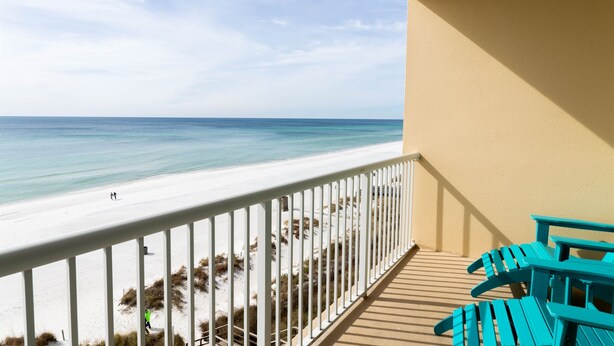 Ein Balkon mit Blick auf Strand und Meer.
