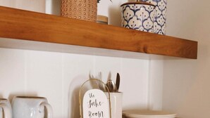 A kitchen with wooden shelves, a coffee maker, a kettle, and a sign that reads 'The Jake Room'. - The Lake Room - #12 (Whitehall)
