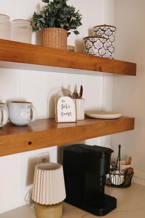 Eine Küche mit Holzböden, einer Kaffeemaschine, einem Wasserkocher und einem Schild mit der Aufschrift 'The Jake Room'.