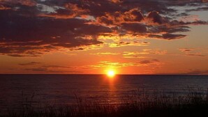 Um pôr do sol sobre a água, com horizonte nítido.