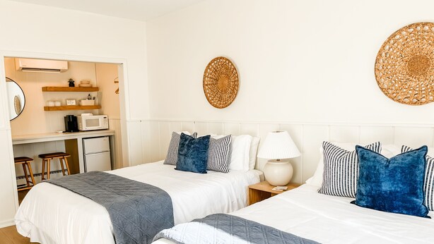 A hotel room with two beds, a kitchenette, and a dining area. - The Midnight Room - #22 (Whitehall)