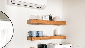 A kitchenette with a white refrigerator, a coffee maker, a microwave, and wooden shelves with kitchenware. - The Midnight Room - #22 (Whitehall)