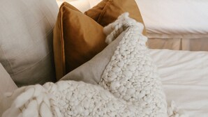 A bedroom with a bed, pillows, a bedside lamp, and a wall sign. - The Goldie Room - #21 (Whitehall)
