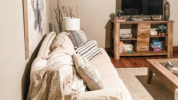 Een gezellige woonkamer met een bank, een tv-meubel en een salontafel.