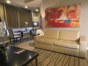 Relax in this stylish room with a sofa, dining area, and abstract art.