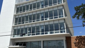 Um edifício com vários andares, grandes janelas e telhado plano.