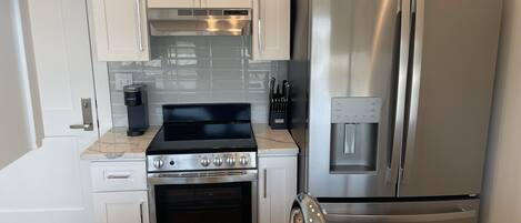A modern kitchen with stainless steel appliances, a built-in oven, and a water dispenser.