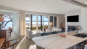 Una cocina moderna con una isla grande, un comedor y vistas a la playa.
