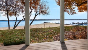 Una terraza de madera con vista a un lago y una playa.