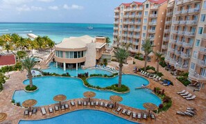 Un resort con una amplia zona de piscina, varias piscinas y vista al océano.
