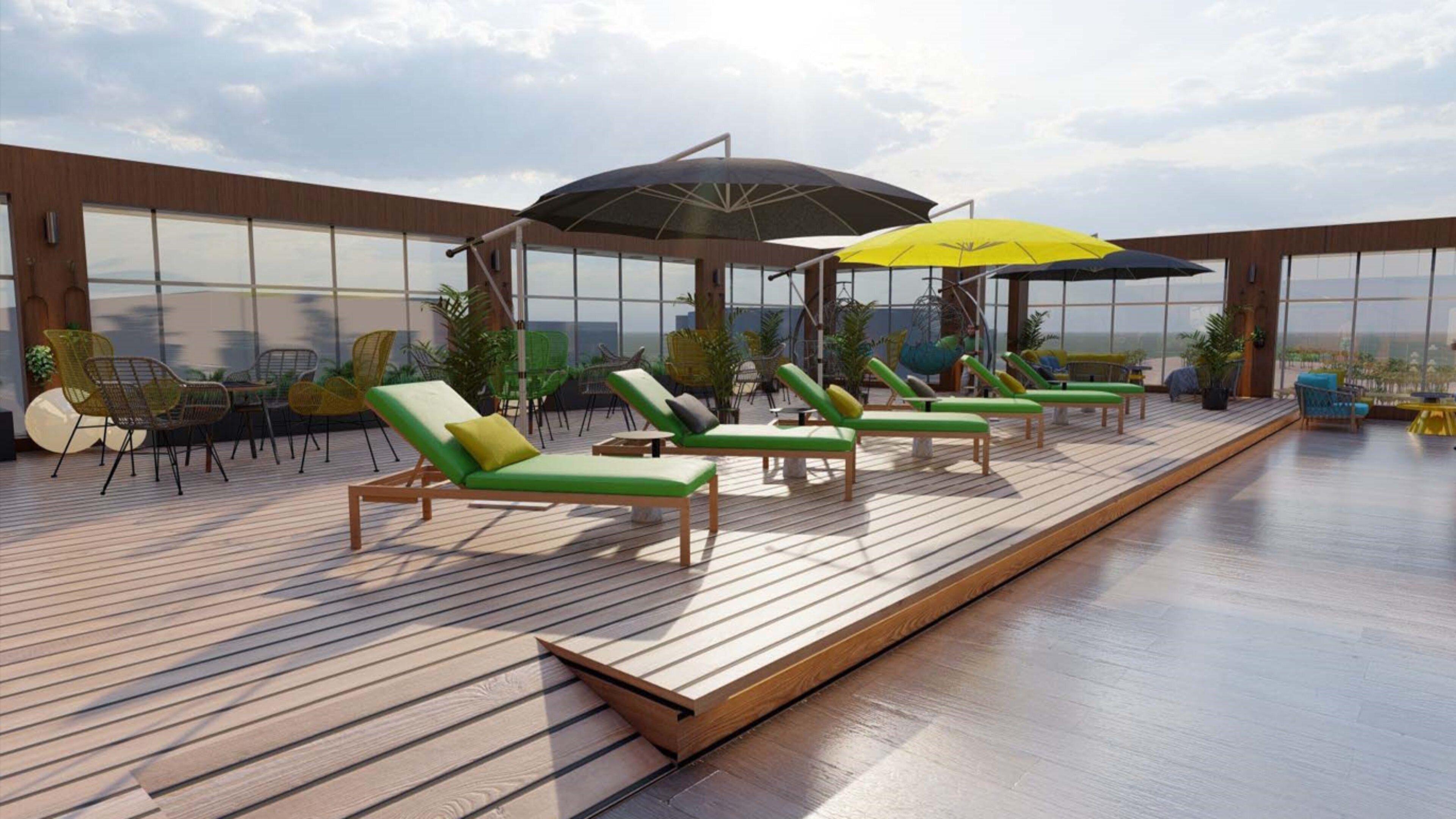 A rooftop lounge area with sun loungers and umbrellas, surrounded by large windows offering a view of the cityscape.