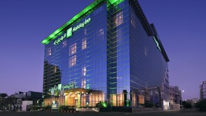 Ein Holiday Inn Hotel mit moderner Glasfassade und beleuchteter Beschilderung.
