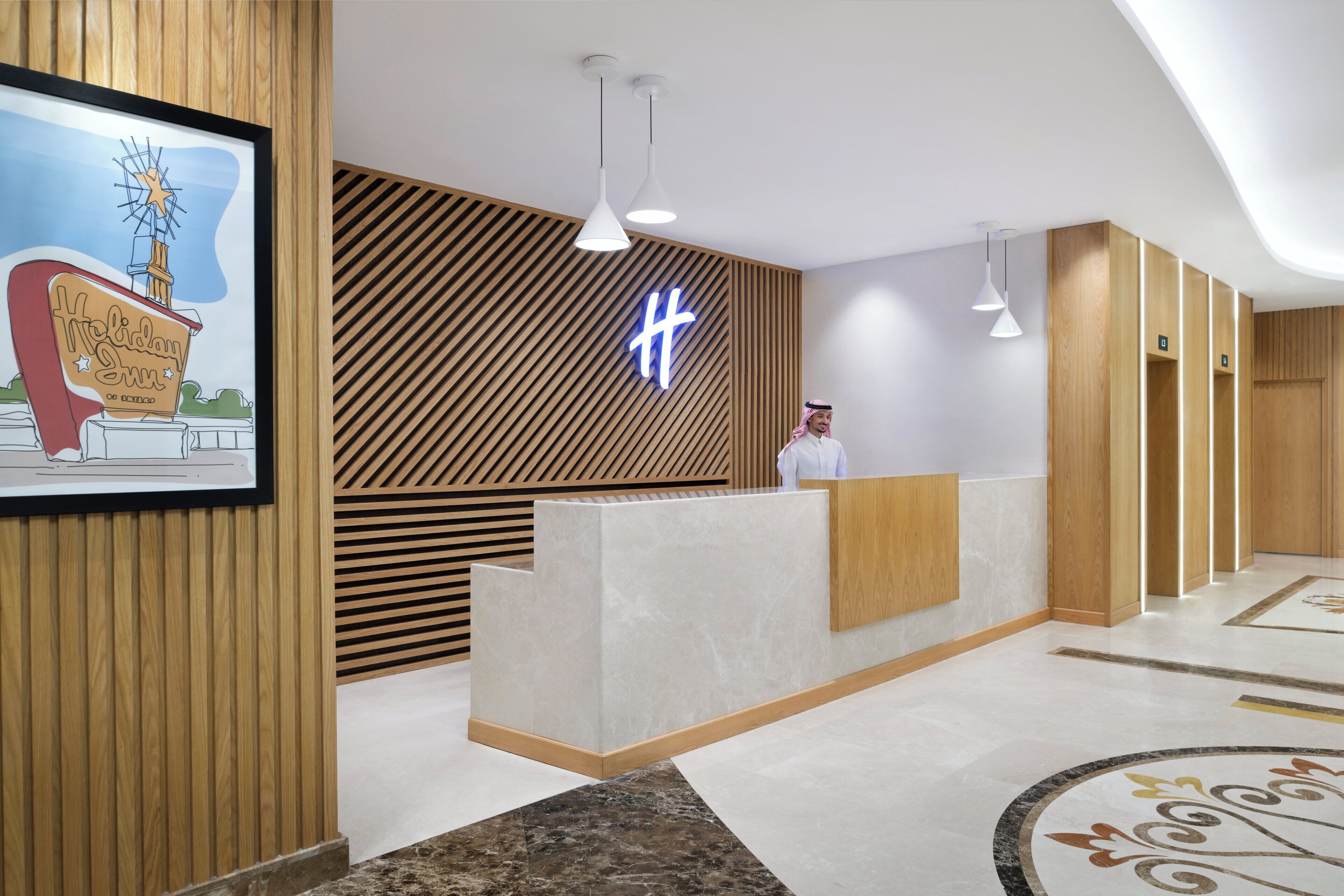 A hotel reception area with a modern design, featuring a wooden panel wall, a reception desk, and a large illuminated 'H' sign.