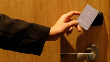 A hand holding a card with "IHG" and "ONE REWARDS" visible.