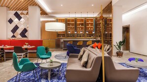 A modern hotel lobby with a sofa, chairs, a dining area, and a bar. - Holiday Inn Express Kathmandu Naxal by IHG (Kathmandu)