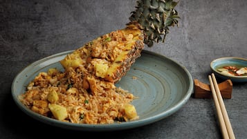 Une assiette de riz frit aux ananas, servie dans une assiette en céramique bleue.