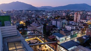 A cityscape at dusk with a rooftop bar featuring outdoor seating and a view of the city. - Holiday Inn Express Kathmandu Naxal by IHG (Kathmandu)