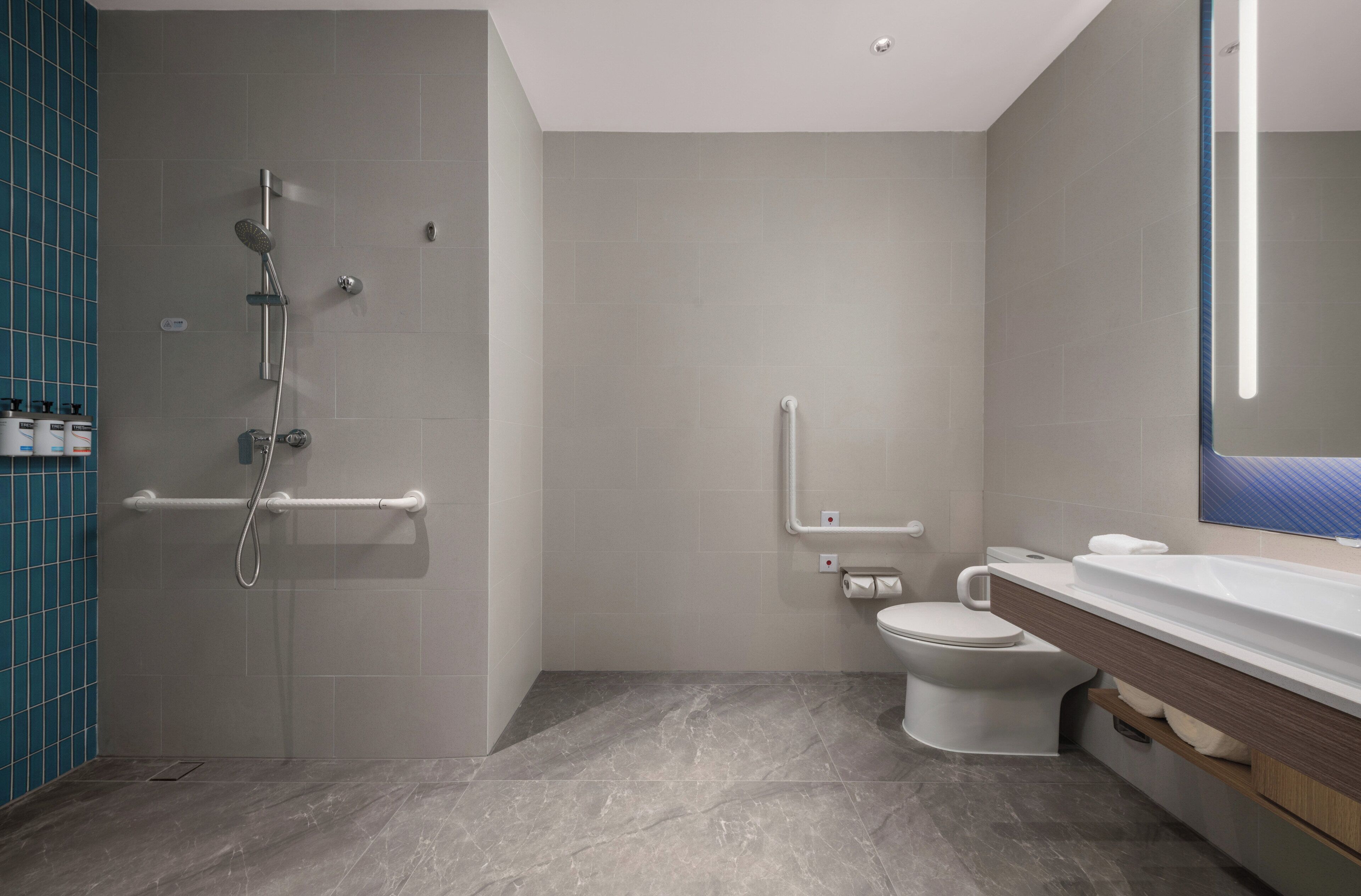 A modern bathroom with a shower, toilet, and vanity.