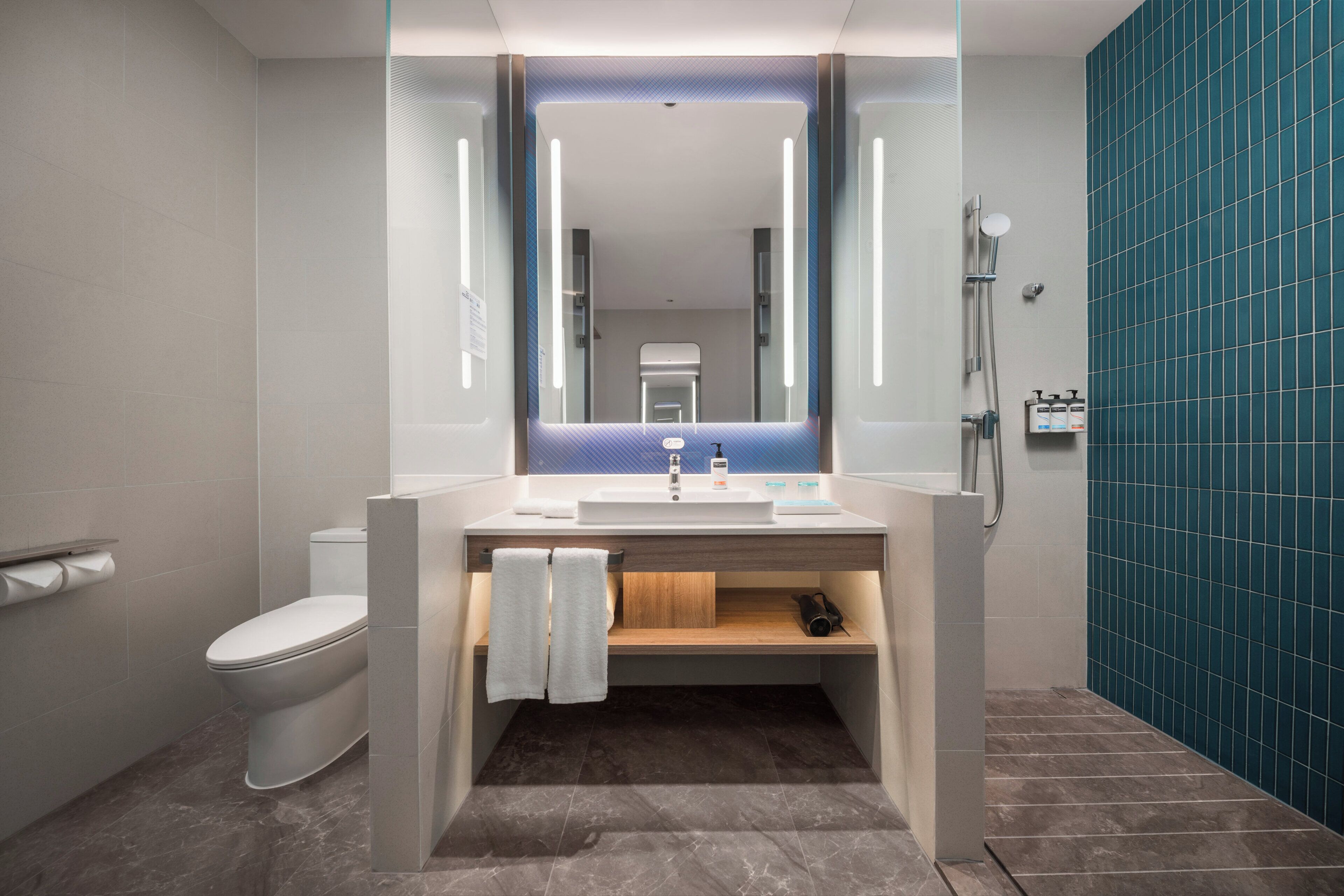 A modern bathroom with a toilet, sink, and shower.