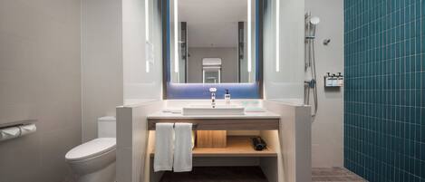 Une salle de bain moderne équipée de toilettes, d’un lavabo et d’une douche.