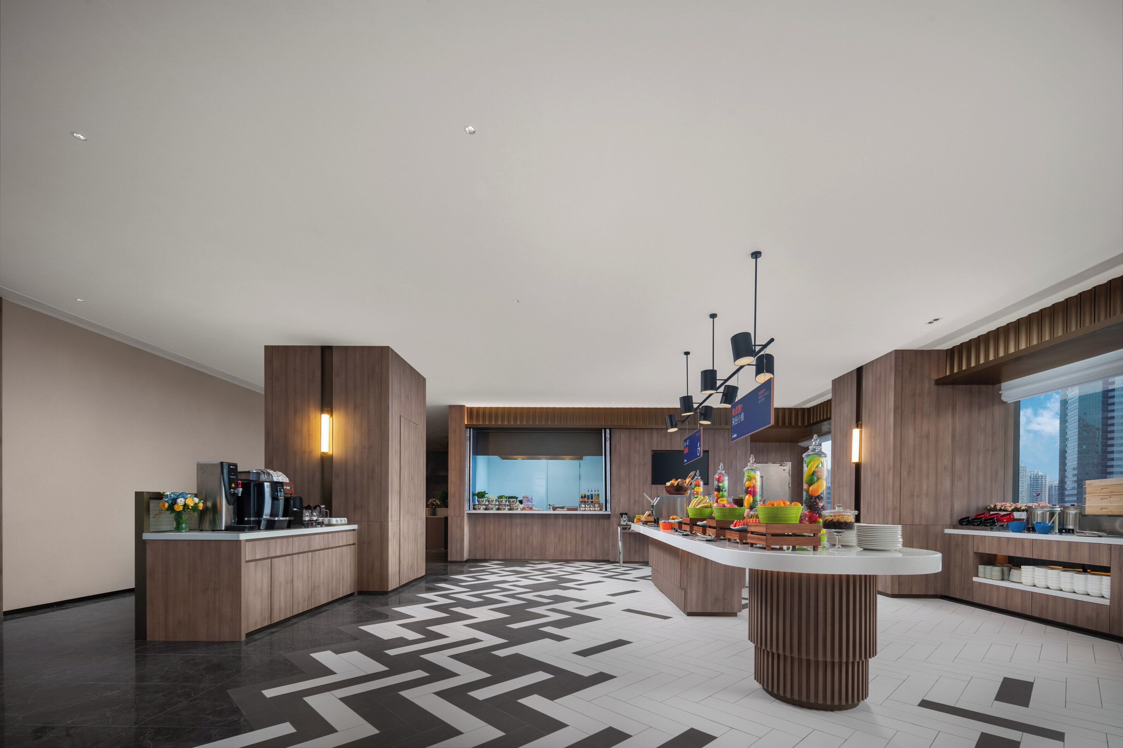 Une cuisine moderne dotée d’un îlot central, d’appareils électroménagers intégrés et d’une grande fenêtre.