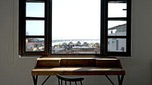 A room with a large window overlooking a bridge and buildings. - Donovan Night Scene by Wynwood (Panama City)