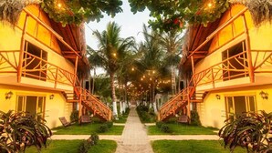 A resort with two-story buildings, a central pathway, and outdoor seating areas. - Waikiki Beach Hostel (Dibulla)