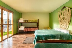 A room with a bunk bed, a single bed, and a macrame wall hanging. - Waikiki Beach Hostel (Dibulla)