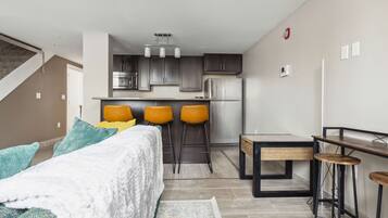 Um apartamento moderno com cozinha, sala de jantar e quarto.