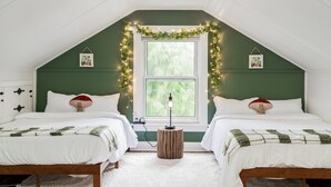 Une chambre confortable avec deux lits, une fenêtre donnant sur un beau paysage et des guirlandes lumineuses.