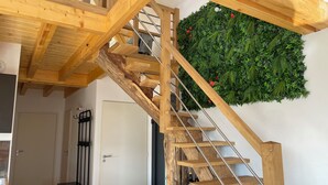A wooden staircase with a green wall at the top. - Gîte des 5 Cépages Avec Jacuzzi (L'Étoile)