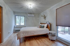 Camera da letto con un letto, una finestra, una lampada a soffitto e un condizionatore d'aria a parete.