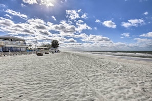 A beach with a building on the left, a tree, and a clear sky. - Near Beach! Modern Ground-Floor Condo in St Pete (St. Pete Beach)