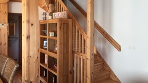 Un escalier en bois doté d’une étagère intégrée où sont disposés des objets décoratifs et des bouteilles.