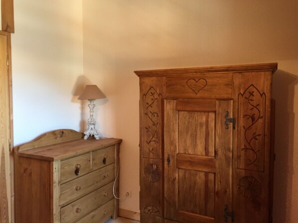 A wooden dresser with drawers and a lamp on top.
