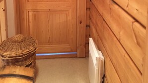 Une porte en bois avec une plaque nominative, un panier en osier et un radiateur.