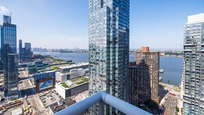 Un edificio alto con fachada de vidrio que ofrece vistas a un paisaje urbano y una masa de agua.