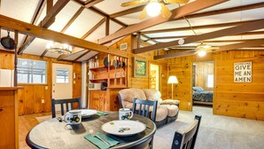 Un'accogliente zona pranzo con tavolo in legno, sedie e ventola a soffitto.