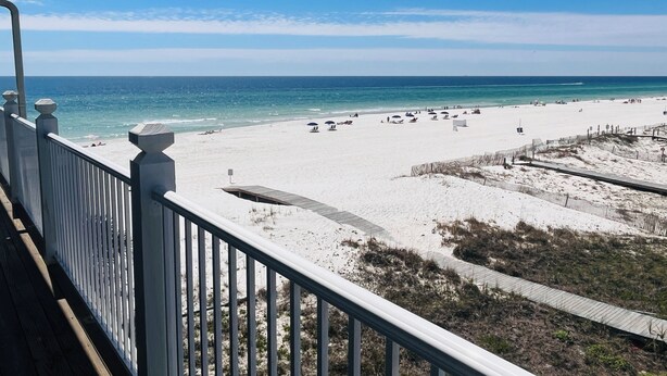 A beach view from a balcony with a railing, sandy beach, and ocean. - Sunchase #303: Steps to Beach! Great View! (Gulf Shores)