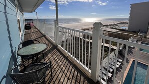 A balcony with a view of the beach and ocean, a pool, and outdoor furniture. - Sunchase #303: Steps to Beach! Great View! (Gulf Shores)