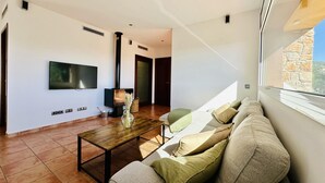 Una sala de estar moderna con un sofá, una mesa de centro, un televisor y una chimenea.