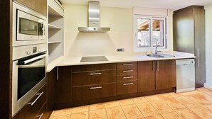 Una cocina moderna con electrodomésticos integrados, una ventana y lavavajillas.