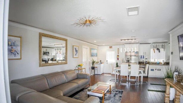 Ein modernes Wohnzimmer mit Sofa, Couchtisch und einem Essbereich mit Stühlen.
