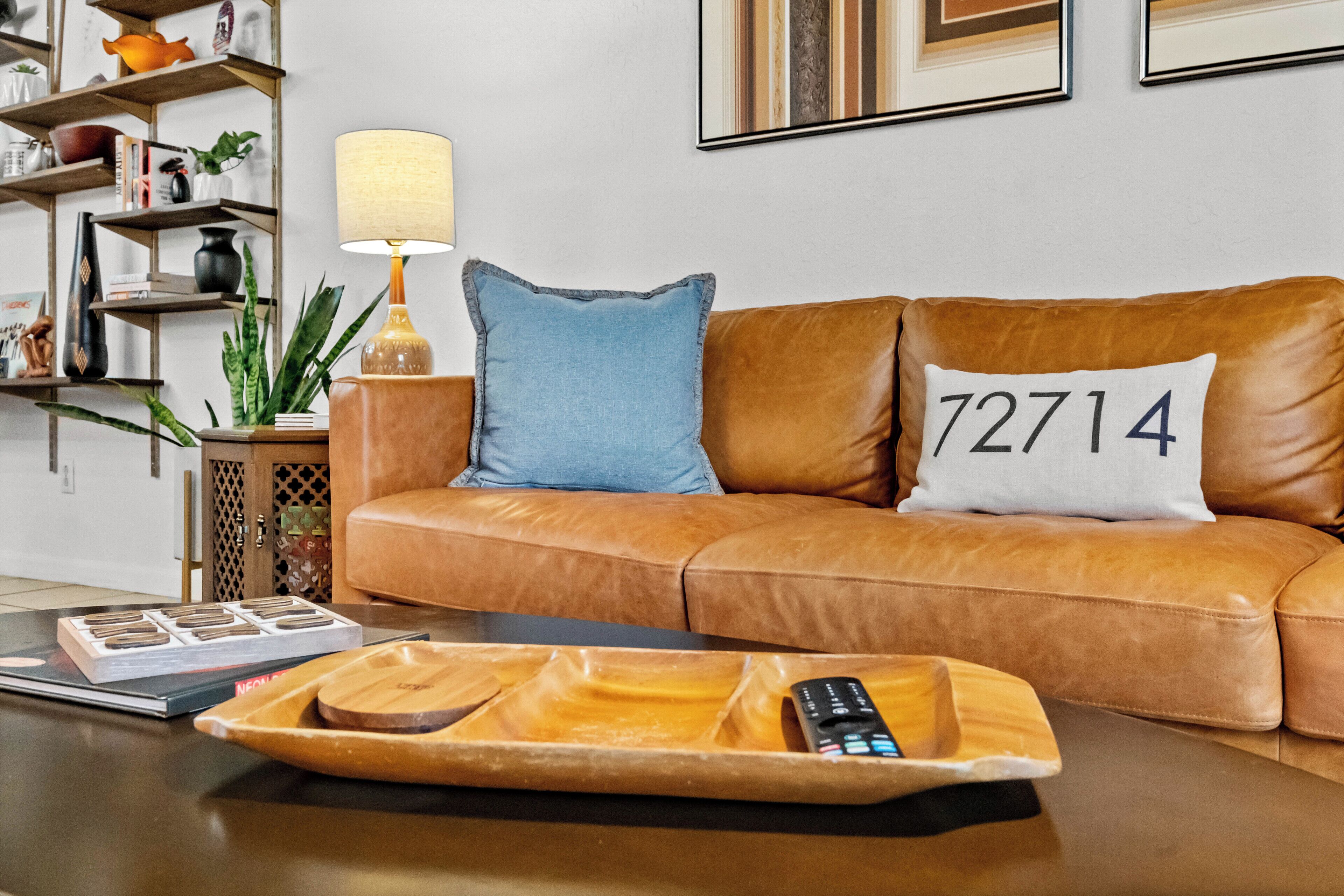 A brown leather sofa with two pillows, one blue and one with the number 72714.