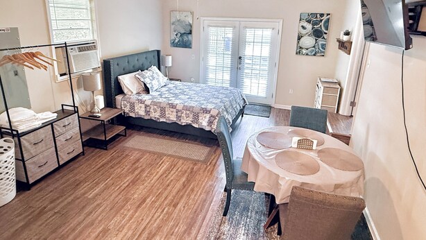 A bedroom with a bed, bedside table, lamp, wardrobe, and a ceiling fan.