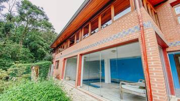 Un bâtiment à deux étages, doté d’une façade en briques, de grandes fenêtres en verre et d’un balcon en bois.