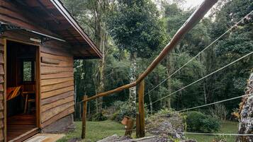Una cabaña rústica de madera con un porche cubierto y una escalera que lleva a una terraza.