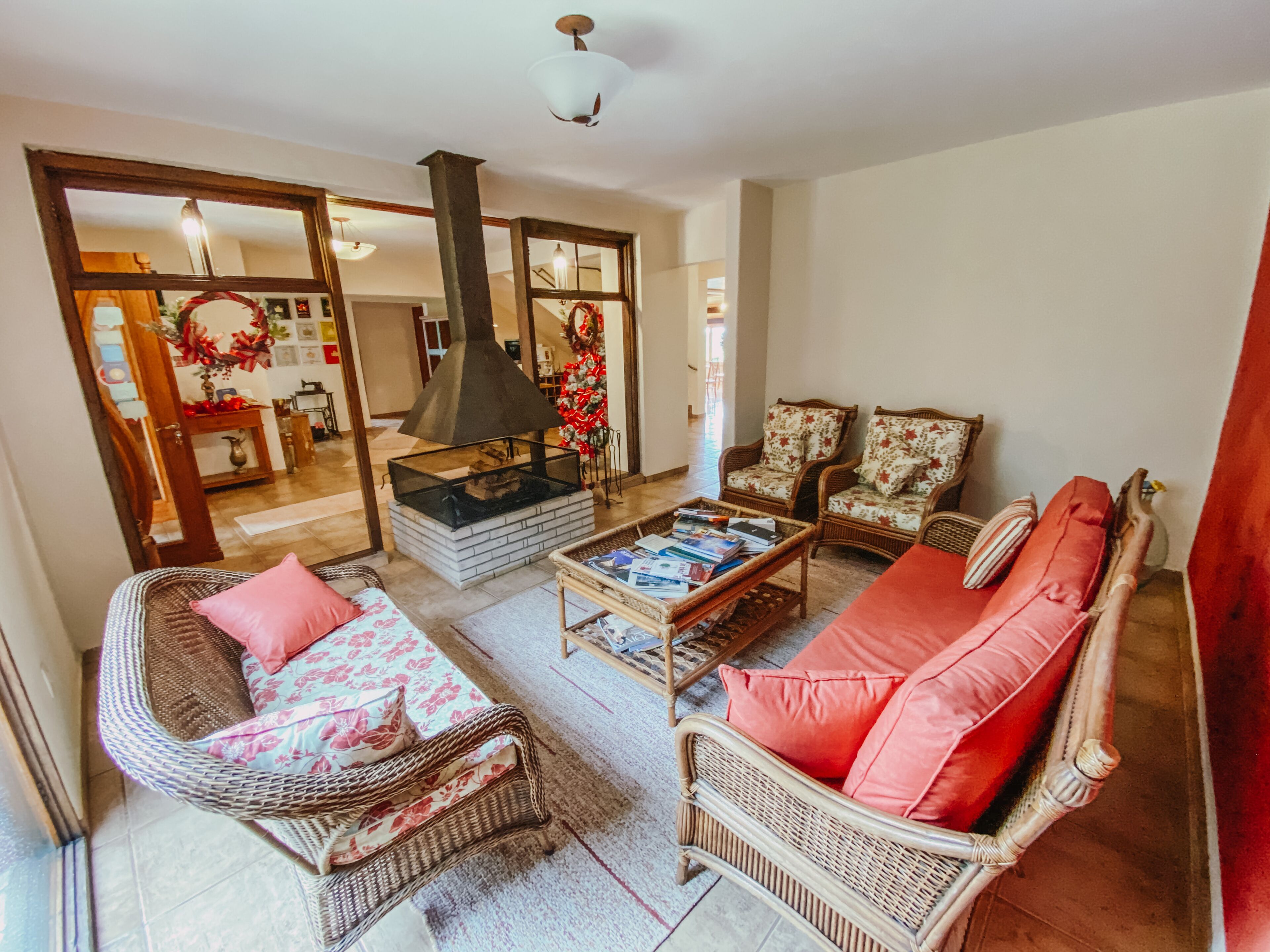 A living room with wicker furniture, a fireplace, and a Christmas tree.